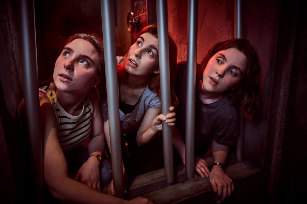 3 Frauen schauen durch Gitterstäbe hindurch
